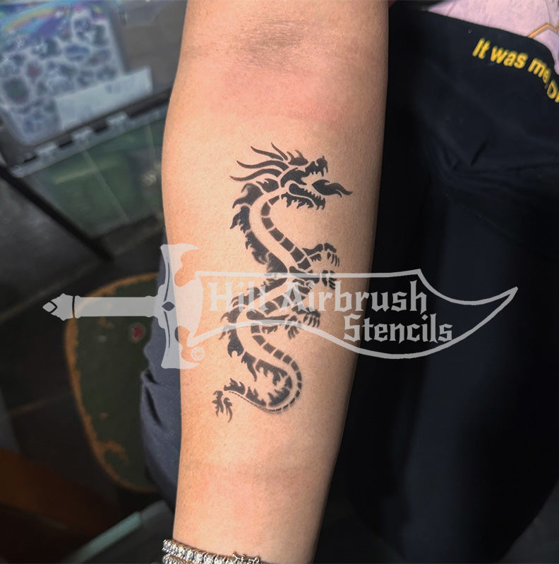 Dragon tattoo airbrushed on a person's arm with a Hilt Airbrush Tattoos stencil.