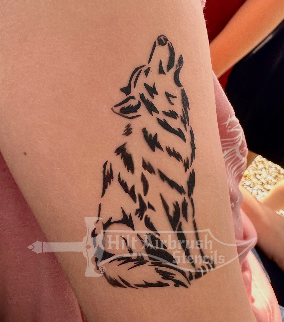 Wolf tattoo design airbrushed on a person's arm using a Hilt Airbrush Stencil.