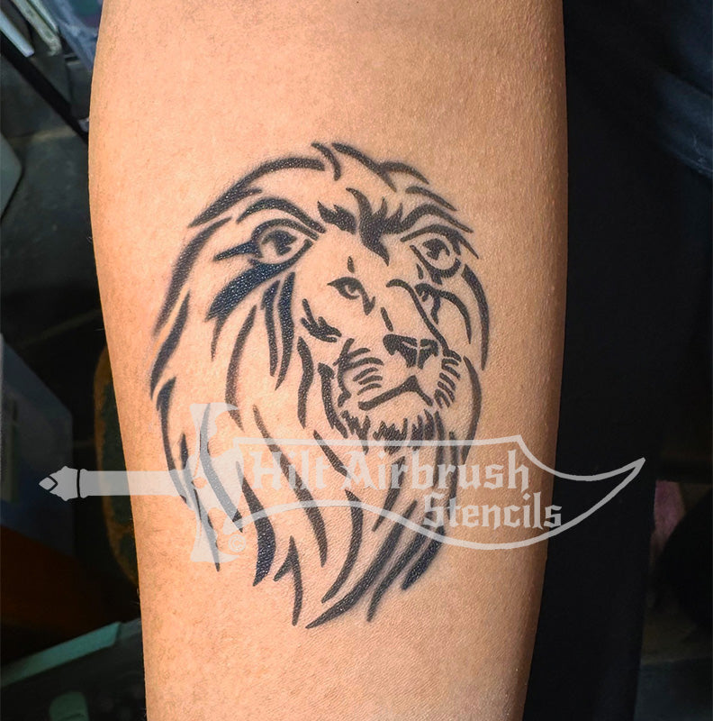 Tattoo of a lion's head on a person's arm created with a stencil by Hilt Airbrush Stencils.