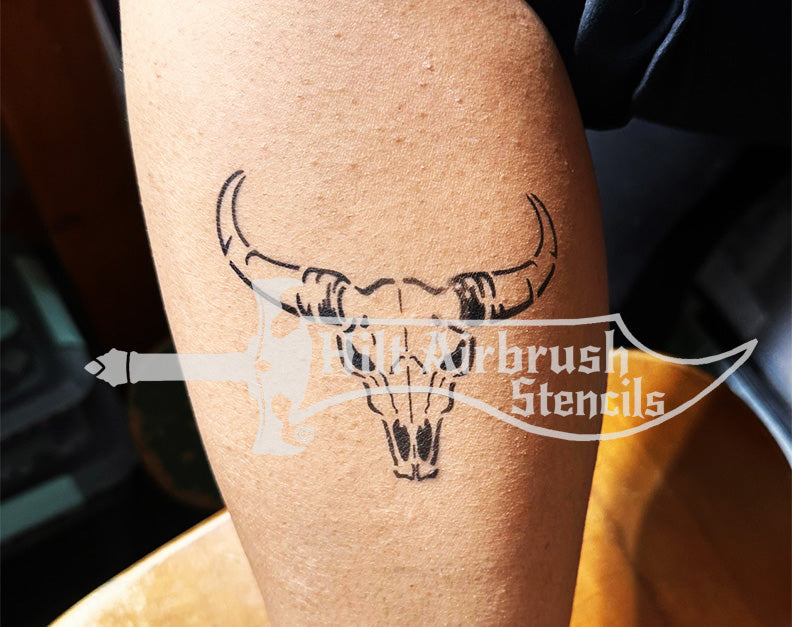 Airbrush tattoo of a western bull skull design sprayed on a person's arm created with a Hilt Airbrush Tattoos stencil.