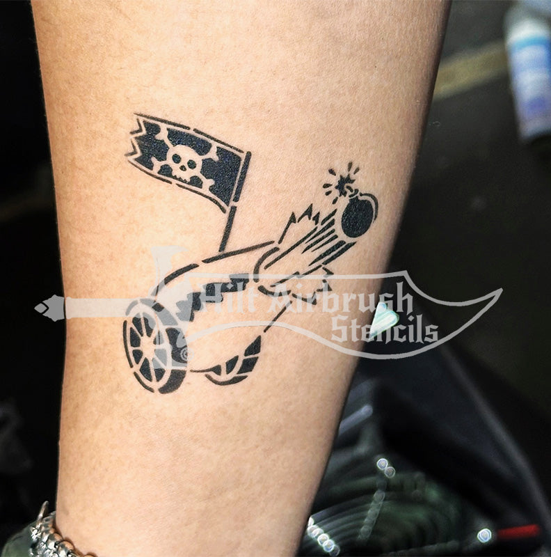 Airbrush tattoo of a cannon with a skull and crossbones flag on a person's arm, created with a stencil from Hilt Airbrush Stencils.