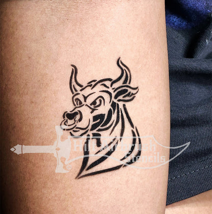 Stylized bull head with horns tattoo airbrushed on a person's arm created with a Hilt Airbrush Stencil.