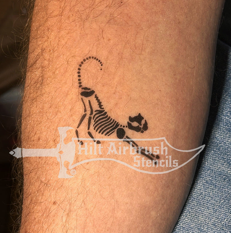 Airbrush tattoo of a skeleton cat on a person's arm created with a stencil from Hilt Airbrush Tattoo Stencils.