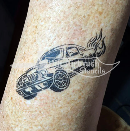An airbrush stencil tattoo of a Mustang car with flames rising from the rear. 