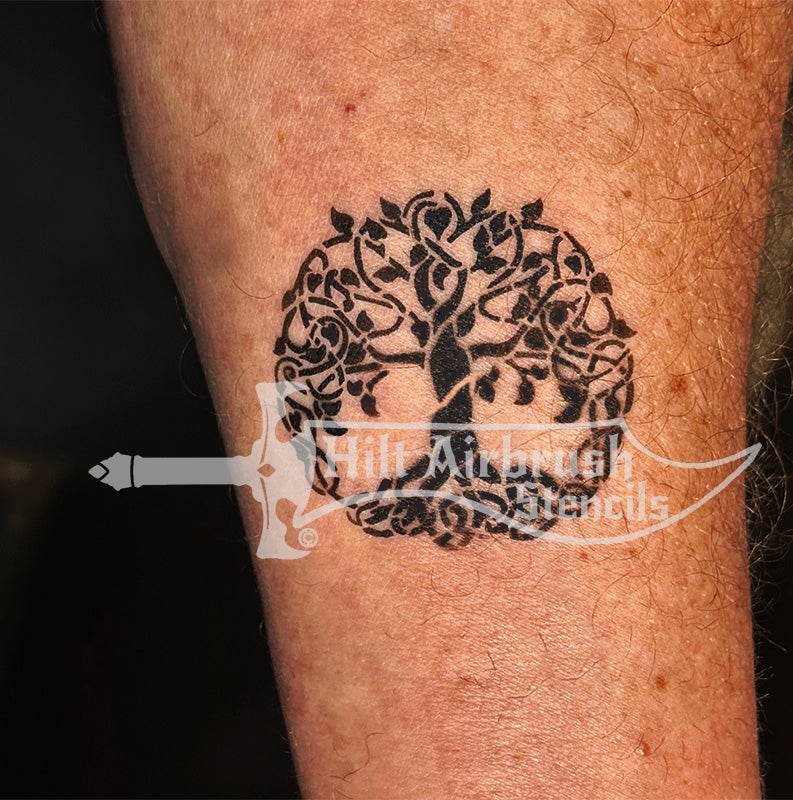 An airbrush tree tattoo on a person's arm designed by Hilt Airbrush Stencils.