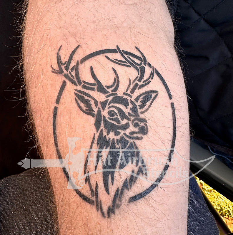 Airbrush tattoo of a deer buck sprayed on a person's arm using a stencil from Hilt Airbrush Stencils.