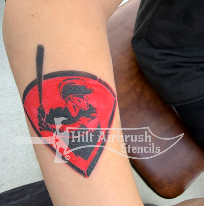 A photo of a temporary tattoo made by a stencil featuring a baseball player holding a bat. 