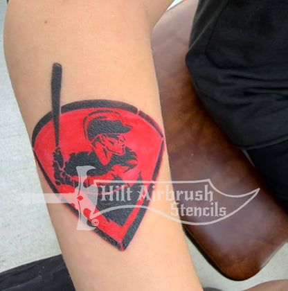 A photo of a temporary tattoo made by a stencil featuring a baseball player holding a bat. 