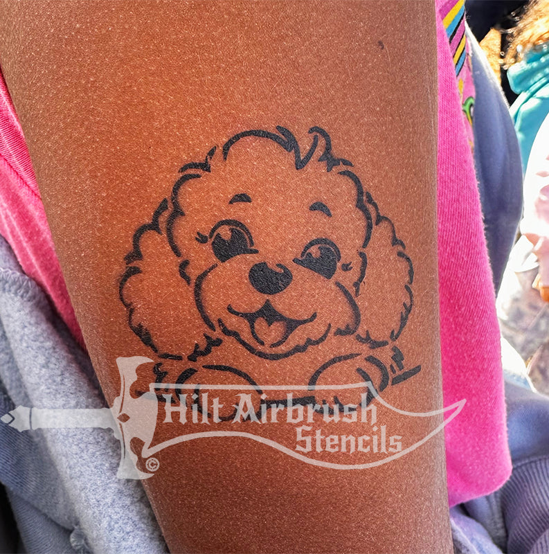 A cute dog tattoo airbrushed on a child's arm designed by Hilt Airbrush Stencils