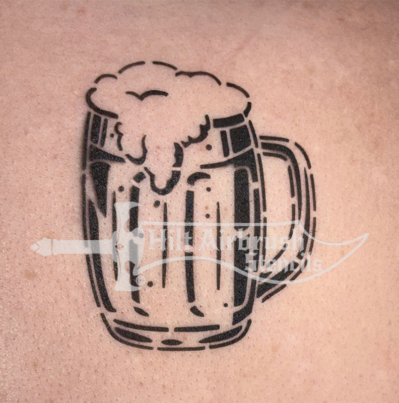 Airbrush tattoo of a beer mug with foam sprayed on a person's arm designed by Hilt Airbrush Stencils