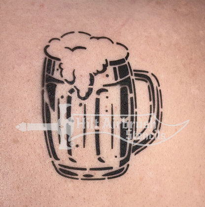 Airbrush tattoo of a beer mug with foam sprayed on a person's arm designed by Hilt Airbrush Stencils