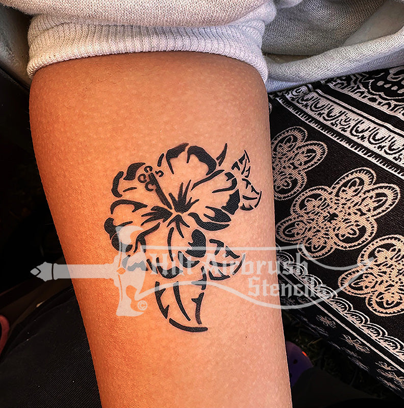 Hibiscus  tattoo airbrushed on a person's arm. Designed by Hilt Airbrush Stencils.