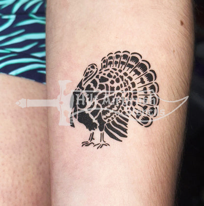 Airbrush tattoo of a turkey sprayed on a person's arm, created with a Hilt Airbrush Stencil.

