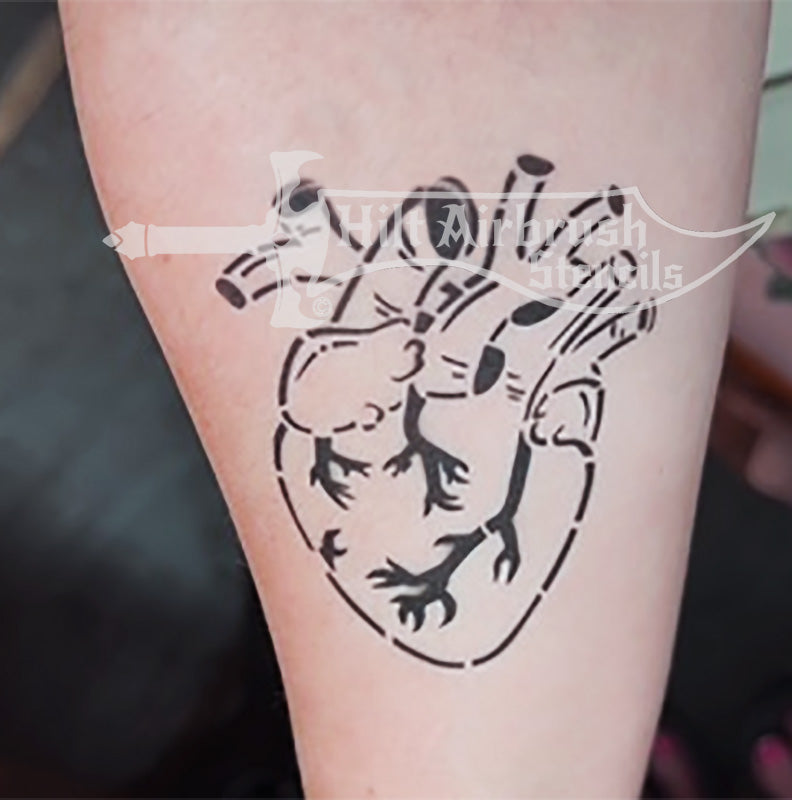A human heart tattoo on a person's arm, designed by Hilt Airbrush Stencils.
