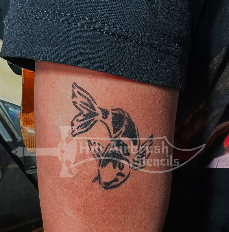 Airbrush tattoo of a koi fish on a person's arm using a stencil from Hilt Airbrush Stencils.