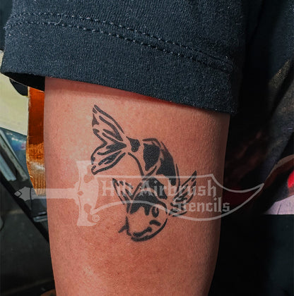 Airbrush tattoo of a koi fish on a person's arm using a stencil from Hilt Airbrush Stencils.